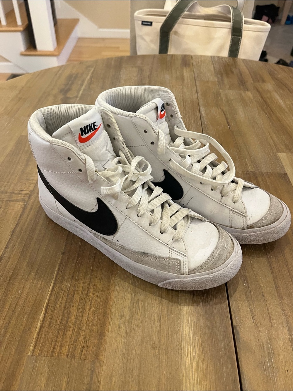 Nike White High-Top Sneakers with Black Swoosh and Orange Logo